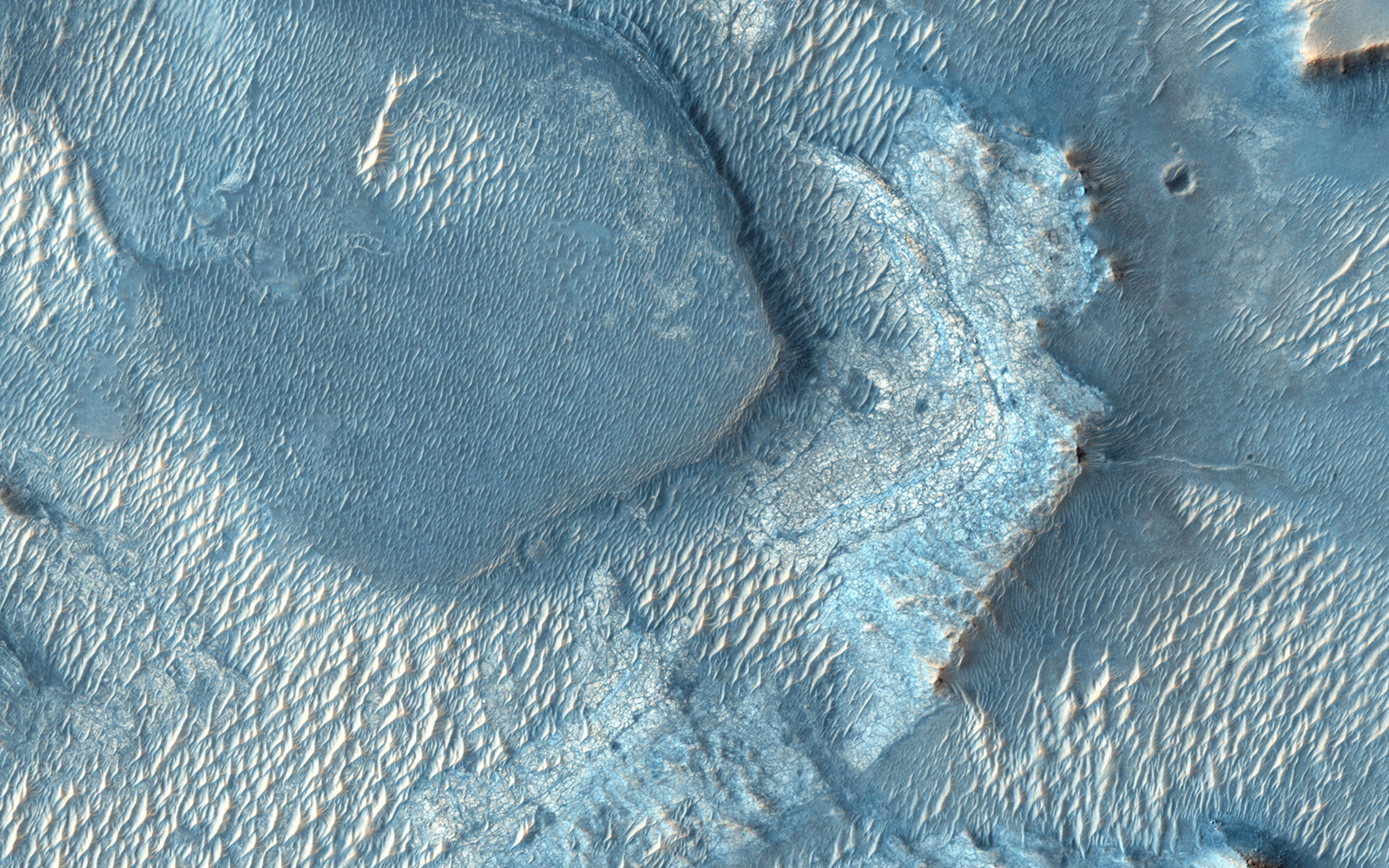 A color image of Nili Fossae with large light and dark-toned bands of minerals.