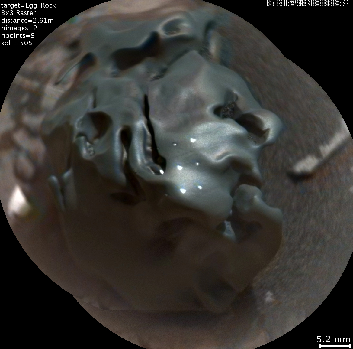 The dark, golf-ball-size object in this composite, colorized view from the ChemCam  instrument on NASA's Curiosity Mars rover is a nickel-iron meteorite, as confirmed by analysis using laser pulses from ChemCam on Oct. 30, 2016. The grid of bright spots on the rock resulted from the laser pulses.
