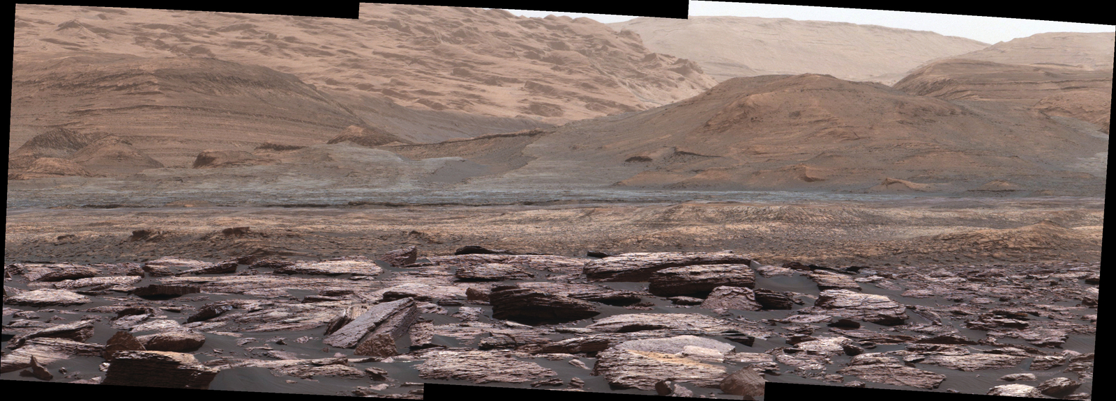 The foreground of this scene from the Mastcam on NASA's Curiosity Mars rover shows purple-hued rocks near the rover's late-2016 location. The middle distance includes future destinations for the rover. Variations in color of the rocks hint at the diversity of their composition on lower Mount Sharp.