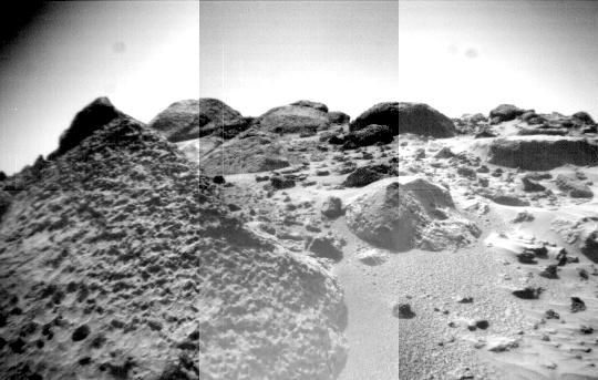 The front cameras aboard the rover Sojourner imaged several prominent rocks on Sol 44. The highly-textured rock at left is Wedge, and in the background from left to right are 'Shark,' 'Half-Dome,' and 'Moe.' Sol 1 began on July 4, 1997.