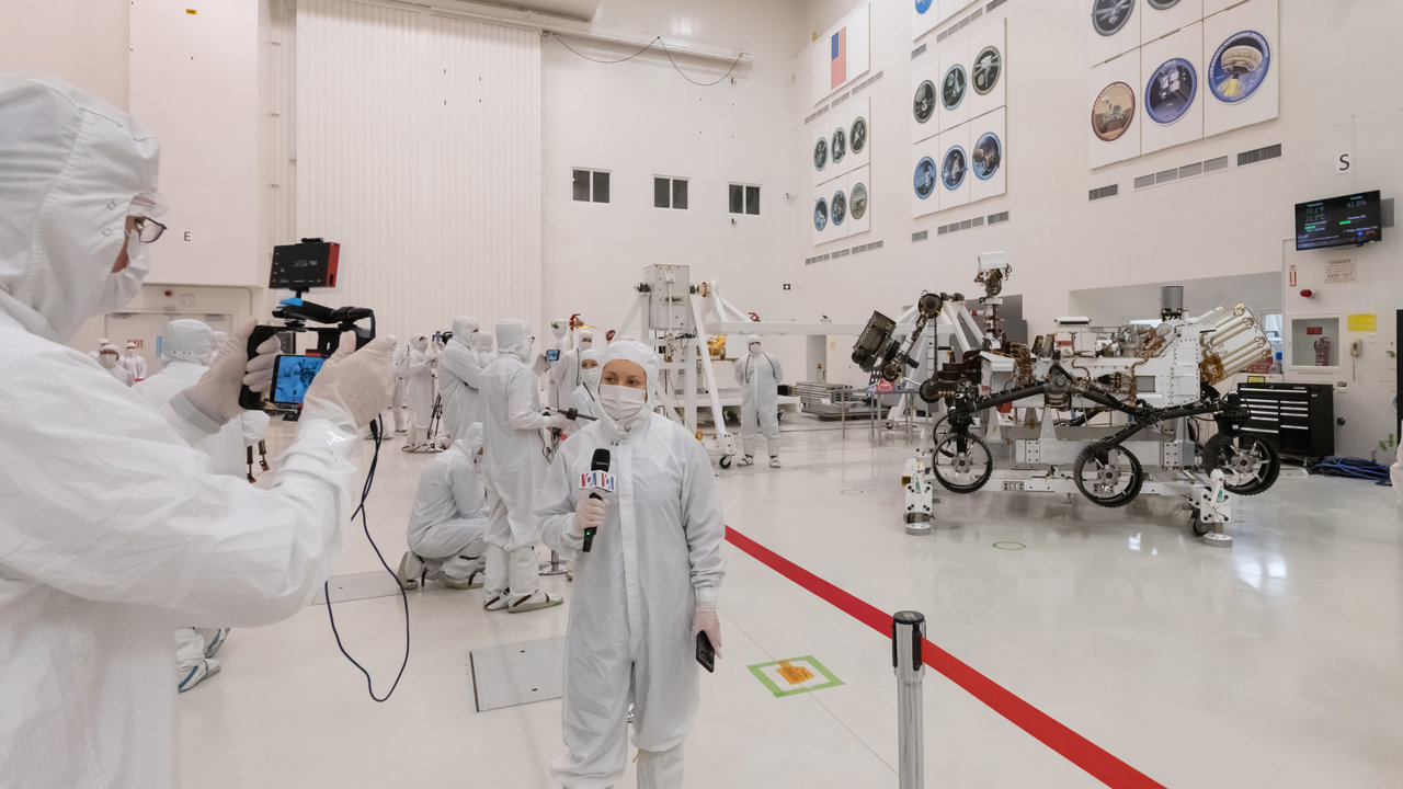 Members of the media interview the builders of the Mars 2020 mission inside JPL's clean room.