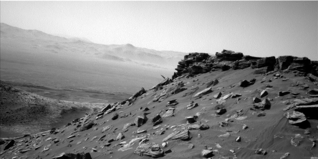 Navcam image showing Curiosity surrounded by topography in our current location.