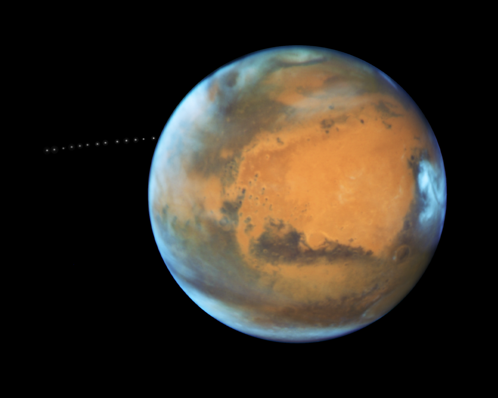 While photographing Mars, NASA's Hubble Space Telescope captured a cameo appearance of the tiny moon Phobos on its trek around the Red Planet.