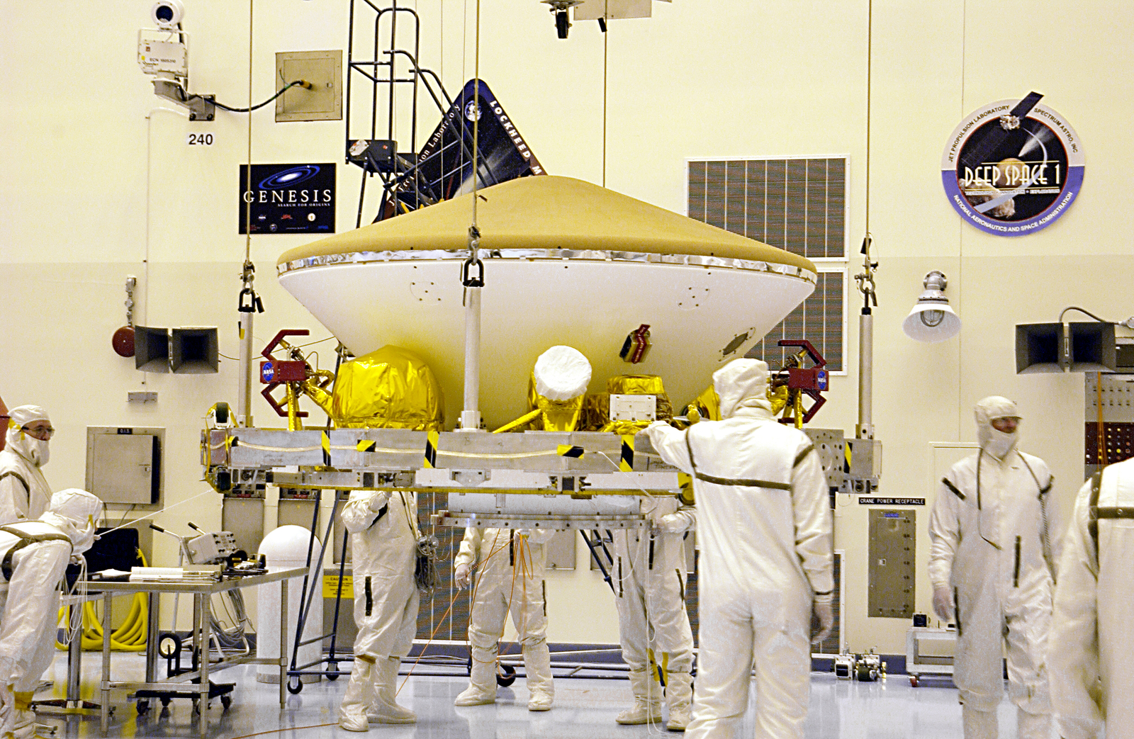 Suspended by an overhead crane in the Payload Hazardous Servicing Facility, the Mars Exploration Rover (MER) aeroshell is guided by workers as it moves to a rotation stand.