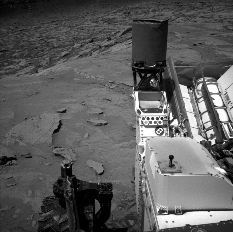 Parts of the rover are visible in this Mars view captured by the Left Navigation camera