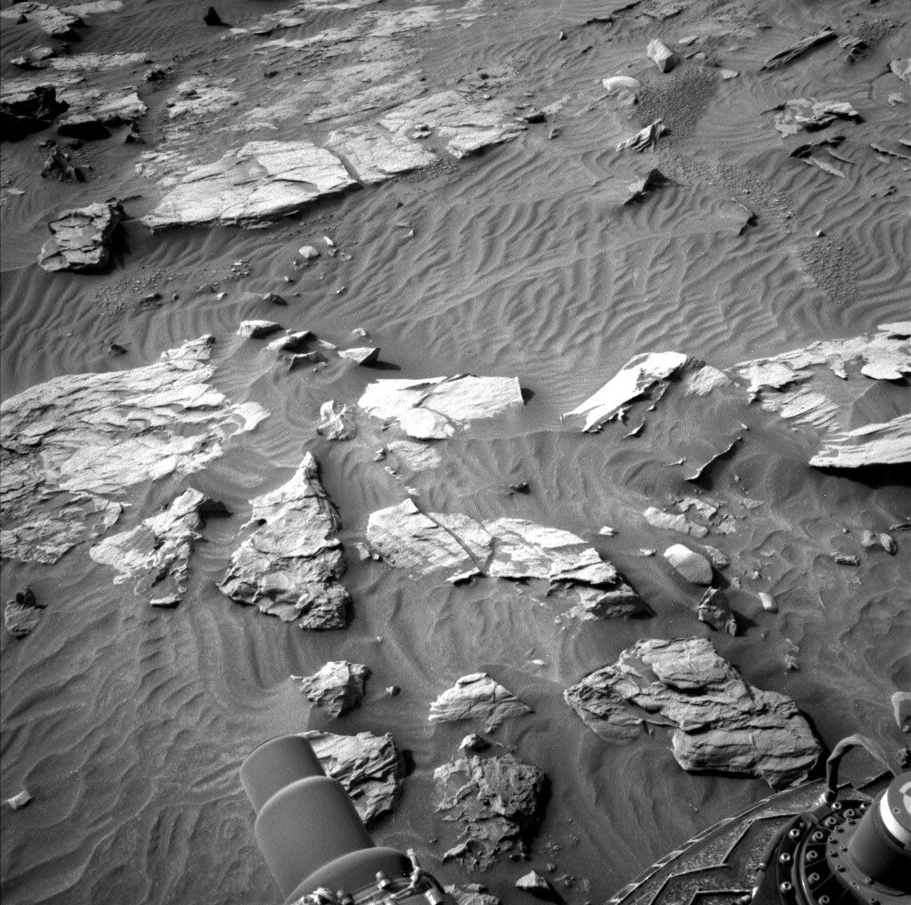 The terrain is currently challenging with sand and float rocks and a hill to climb. This image was taken by Left Navigation Camera onboard NASA's Mars rover Curiosity on Sol 3403.