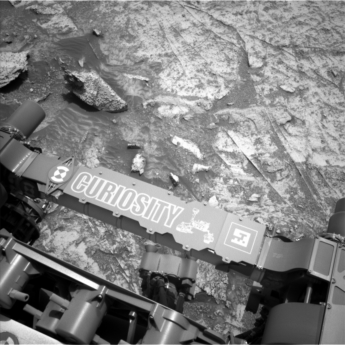 This image was taken by Curiosity's left Navigation camera on sol 3506, showing the large out of place target “Kukui" and "Curiosity" name plate on the rover.
