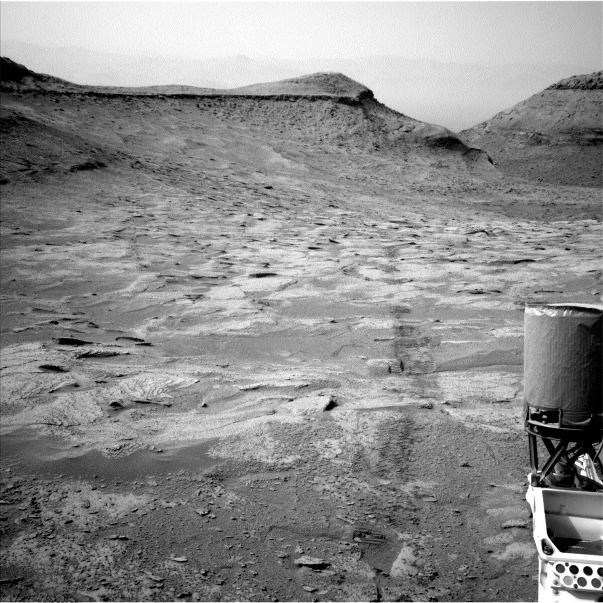 This image showing part of the Curiosity rover and Martian hills ahead was taken by Left Navigation Camera onboard Curiosity on Sol 3708.