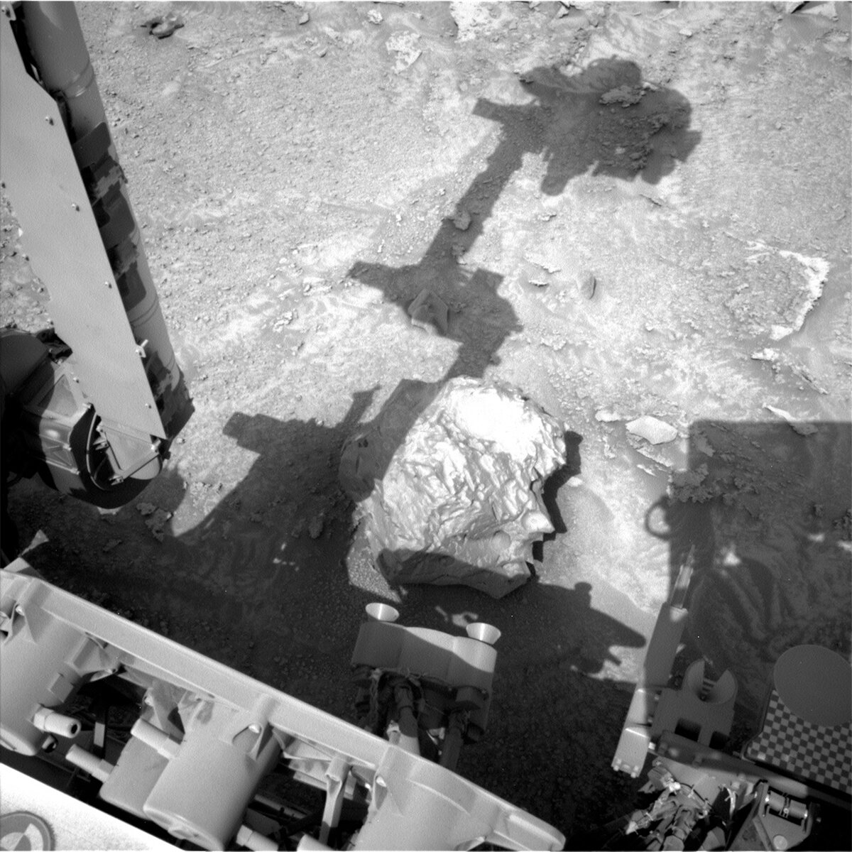 This image showing part of the Curiosity rover and the shadow of its arm above a rock was taken by Left Navigation Camera onboard the Curiosity rover on Sol 3724.