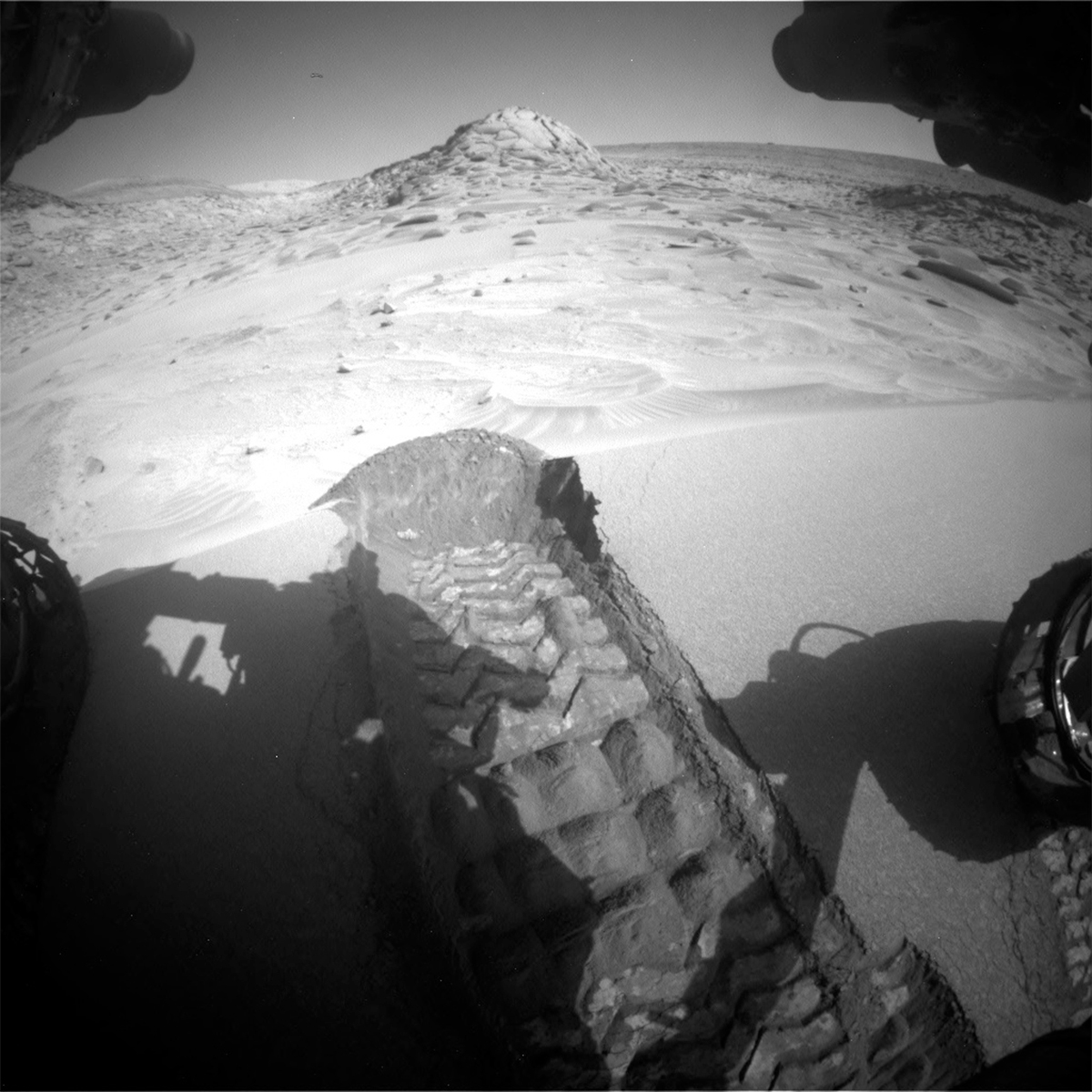 This image shows Curiosity's wheel scuff, nicknamed "Taracua," on the Mars surface and part of the rover's wheels.