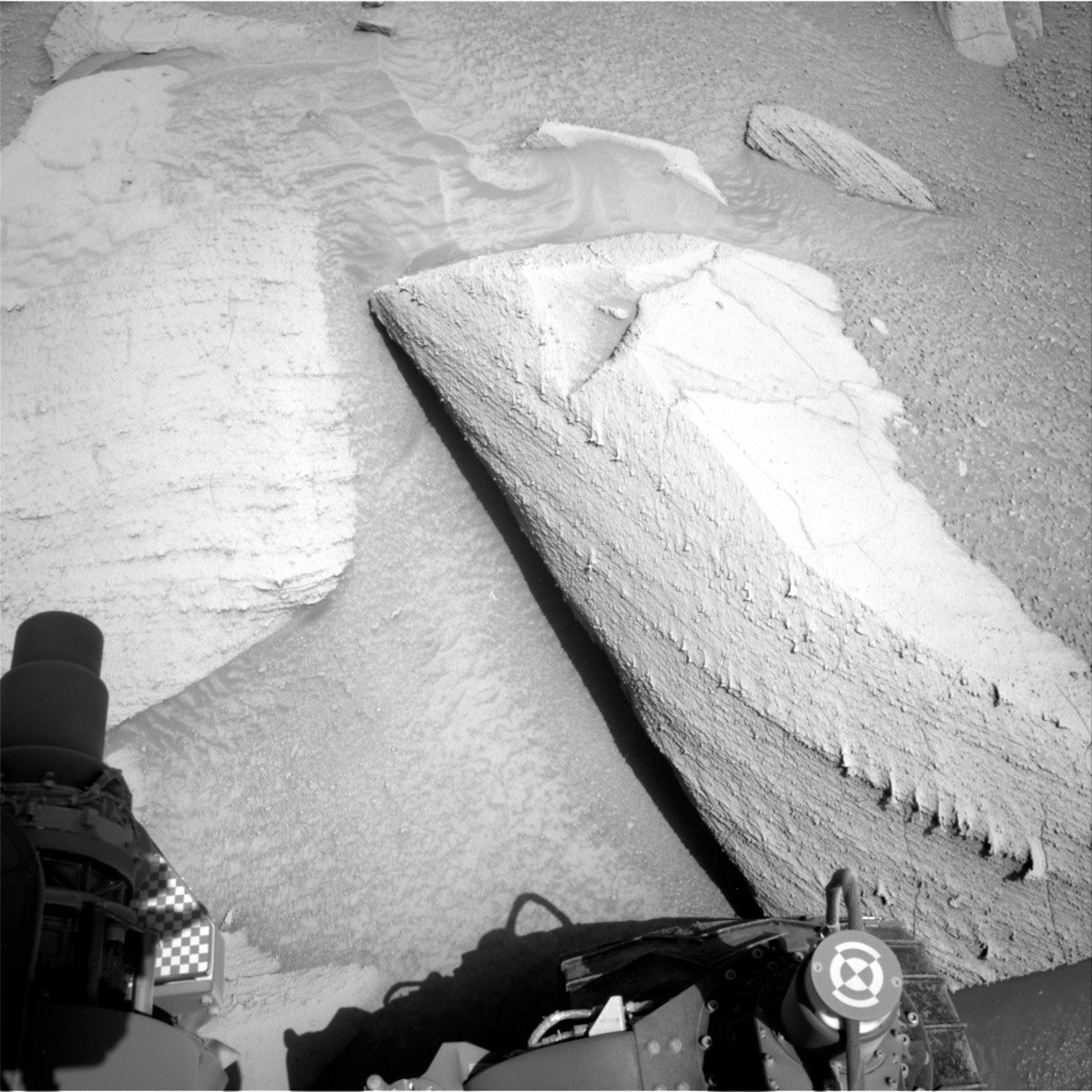 This image of the Martian rock Cupixi and a rock with a "shark's teeth" formation nearby, with the Curiosity rover visible at the edge of the image, was taken by the Curiosity rover on Sol 3797.