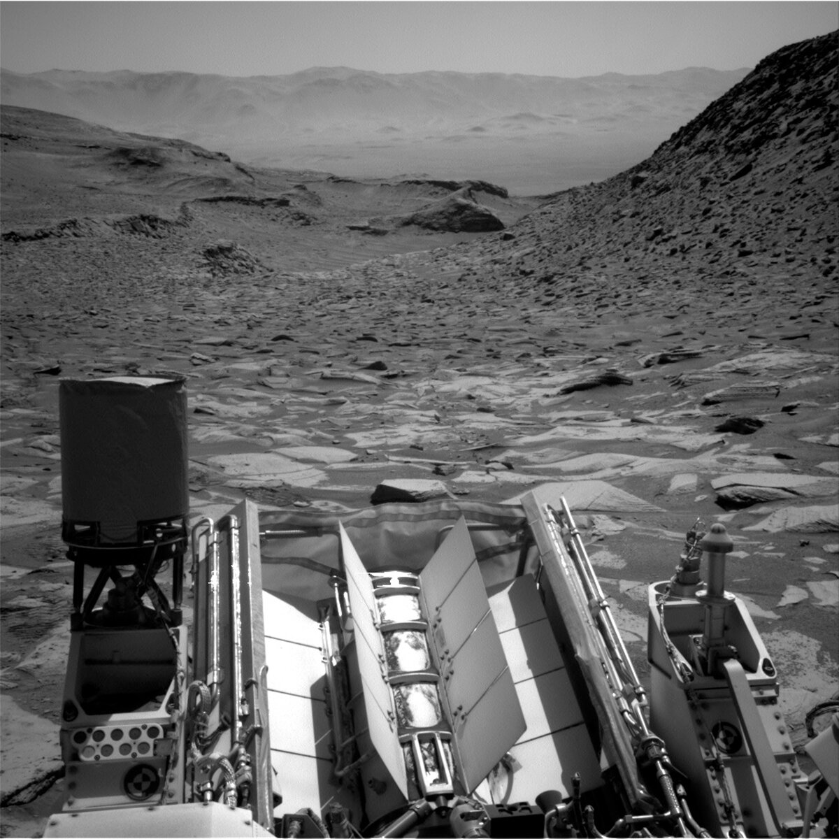 This image shows part of the Curiosity rover overlooking a canyon of rocks on the Mars surface and was taken by Right Navigation Camera onboard Curiosity on Sol 3872.