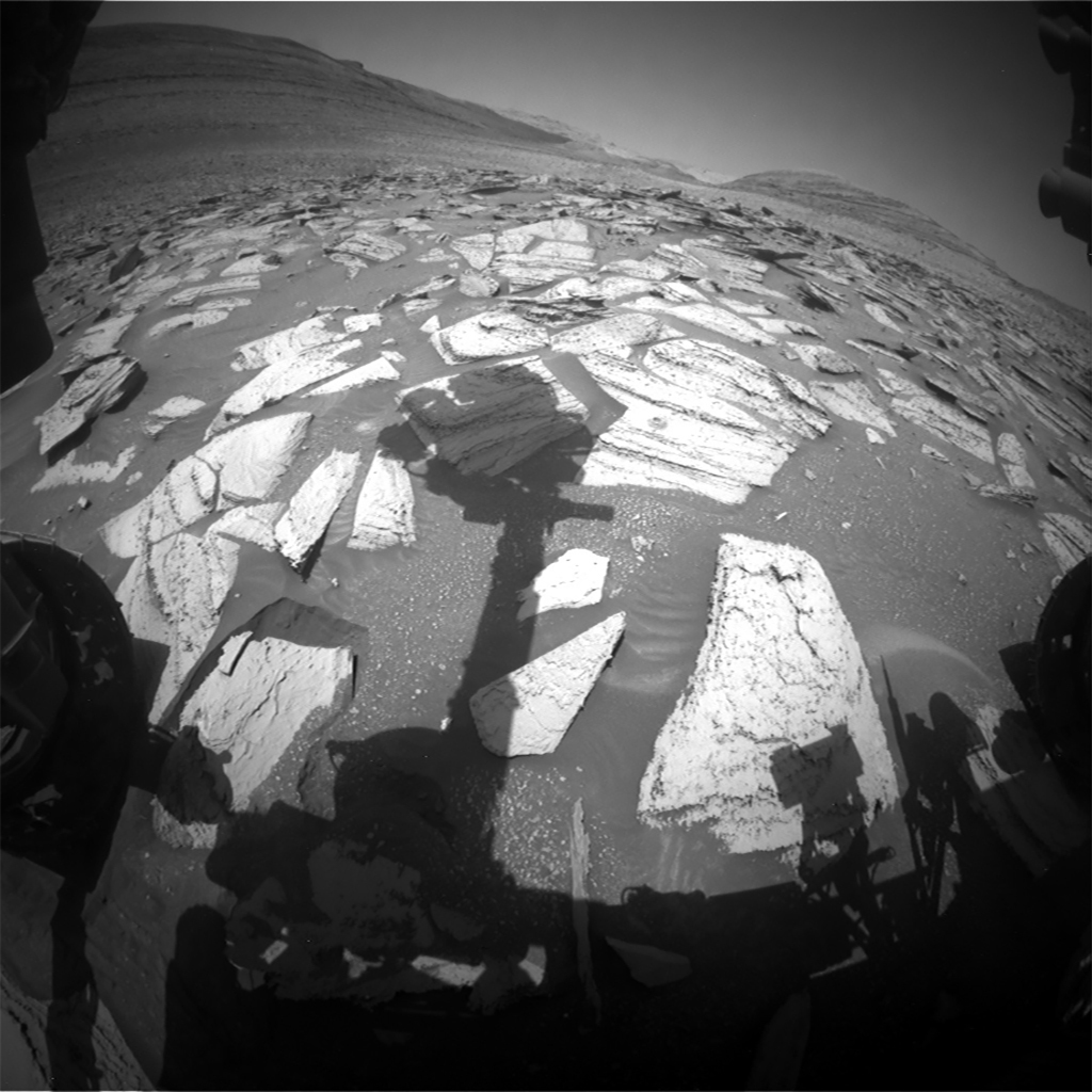 Front Hazcam image from Sol 4024 showing the view ahead of Curiosity as she prepares to drive away from the Sequoia drill site. There is a shadow of the unstowed robotic arm.