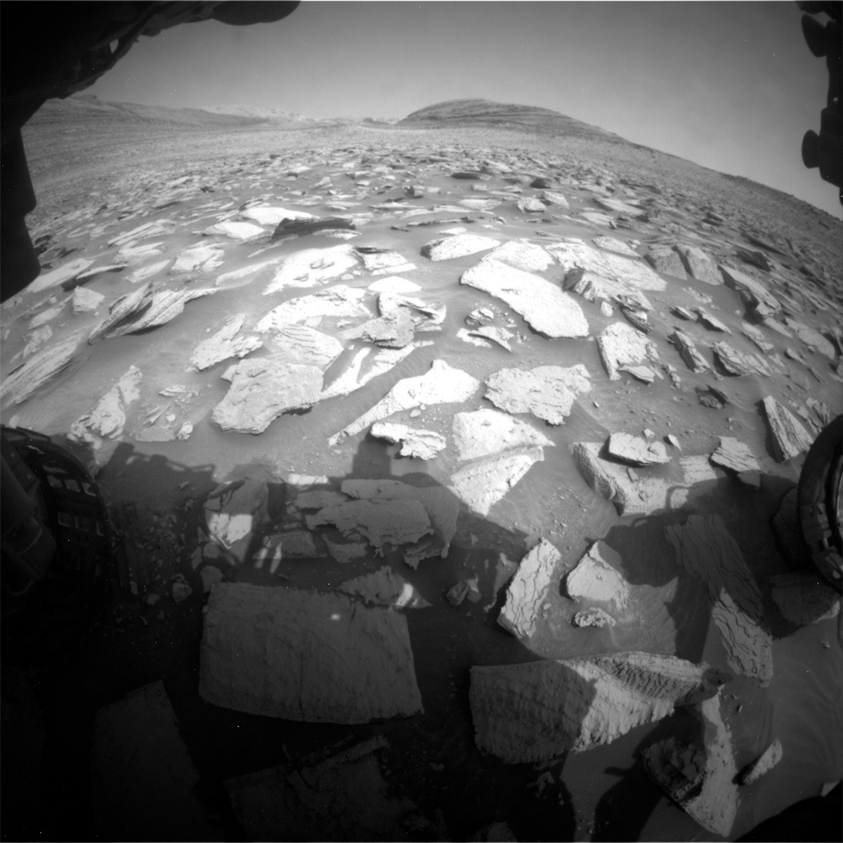 This image of the Mars surface with the rover visible in the edges of the frame was taken by Front Hazard Avoidance Camera onboard NASA's Mars rover Curiosity on Sol 4035.