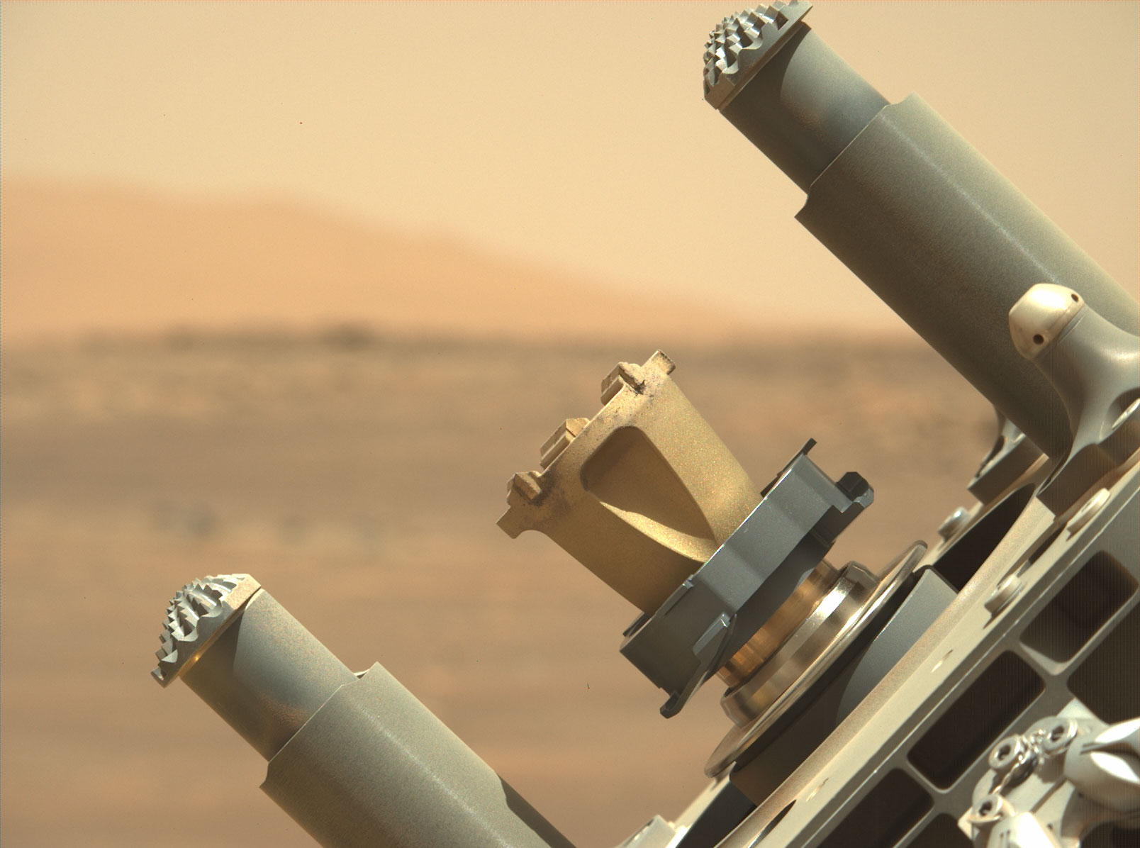 Close-up photo shows detailed side view of Perseverance rover's abrading bit, a broad conical shape with a 5-centimeter diameter flat surface for grinding rocks.