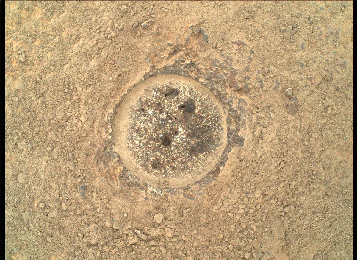 Close-up photo of a Mars rock with a shallow, 5-centimeter-wide hole drilled into it.