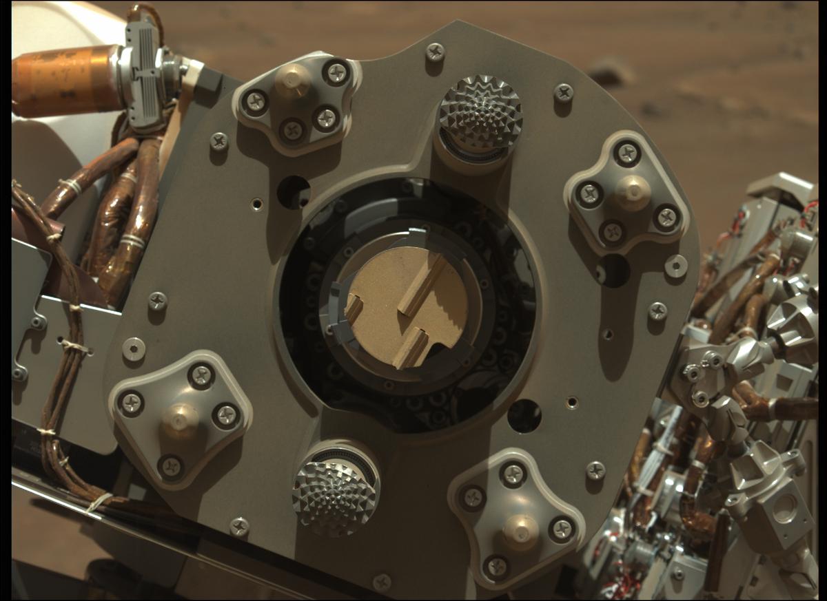 Close-up  photo of Perseverance rover's drill, with its abrading bit facing the camera. The bit has a flat surface, 5 centimeters in diameter, with linear teeth for grinding rocks.