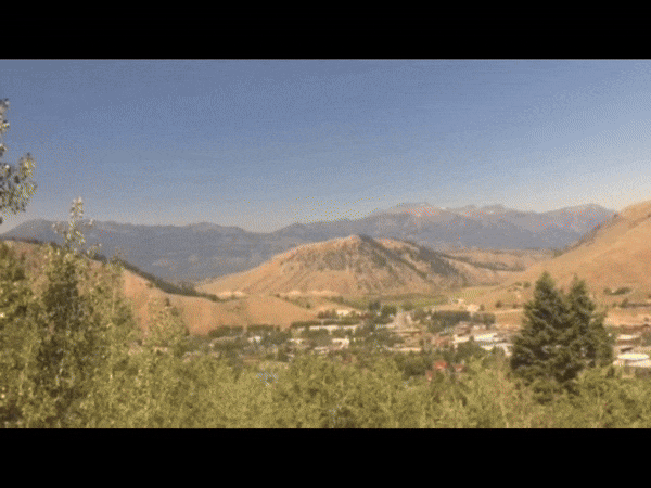 A hilly landscape. A man holds his hand in front of the camera. Shadows on his hand appear to move and shimmer.