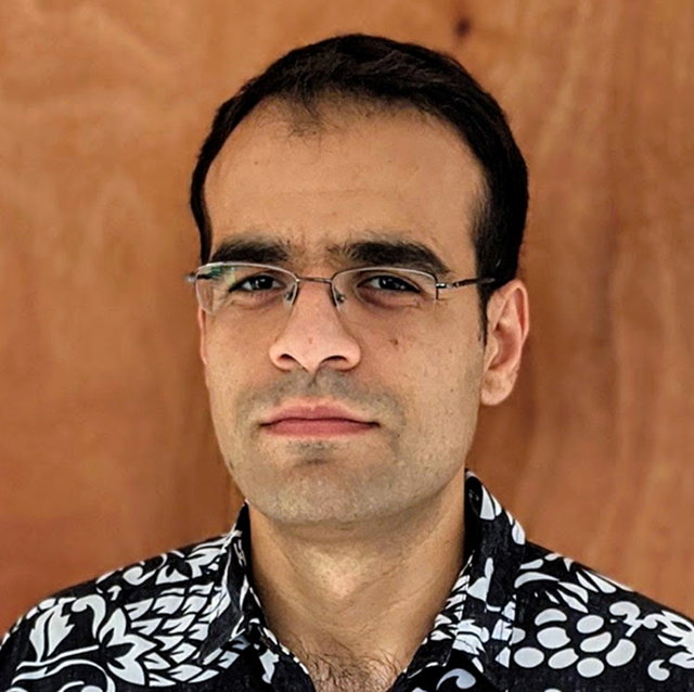 Headshot of Michael Bottom, male, black hair, glasses, faint stubble beard, black and white button-down shirt.