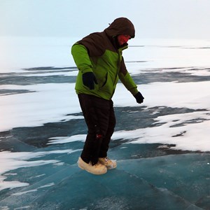 Photo of a man in snow gear standing on ice.