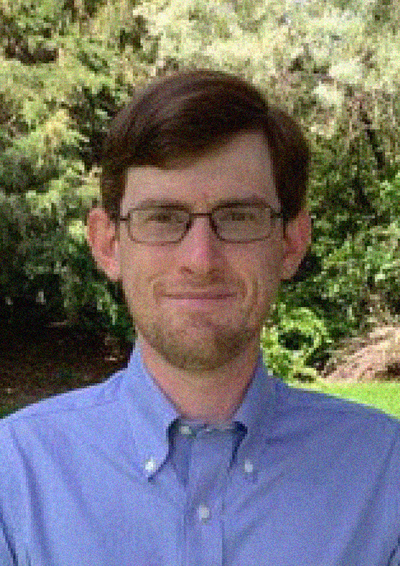 Jake Connors headshot, male, brown hair, glasses, blue button-down shirt, closed-mouth smile.