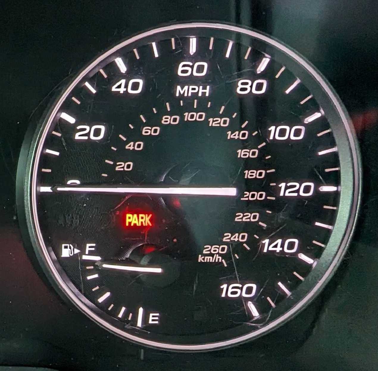 A car's speedometer, showing a full tank of gas.