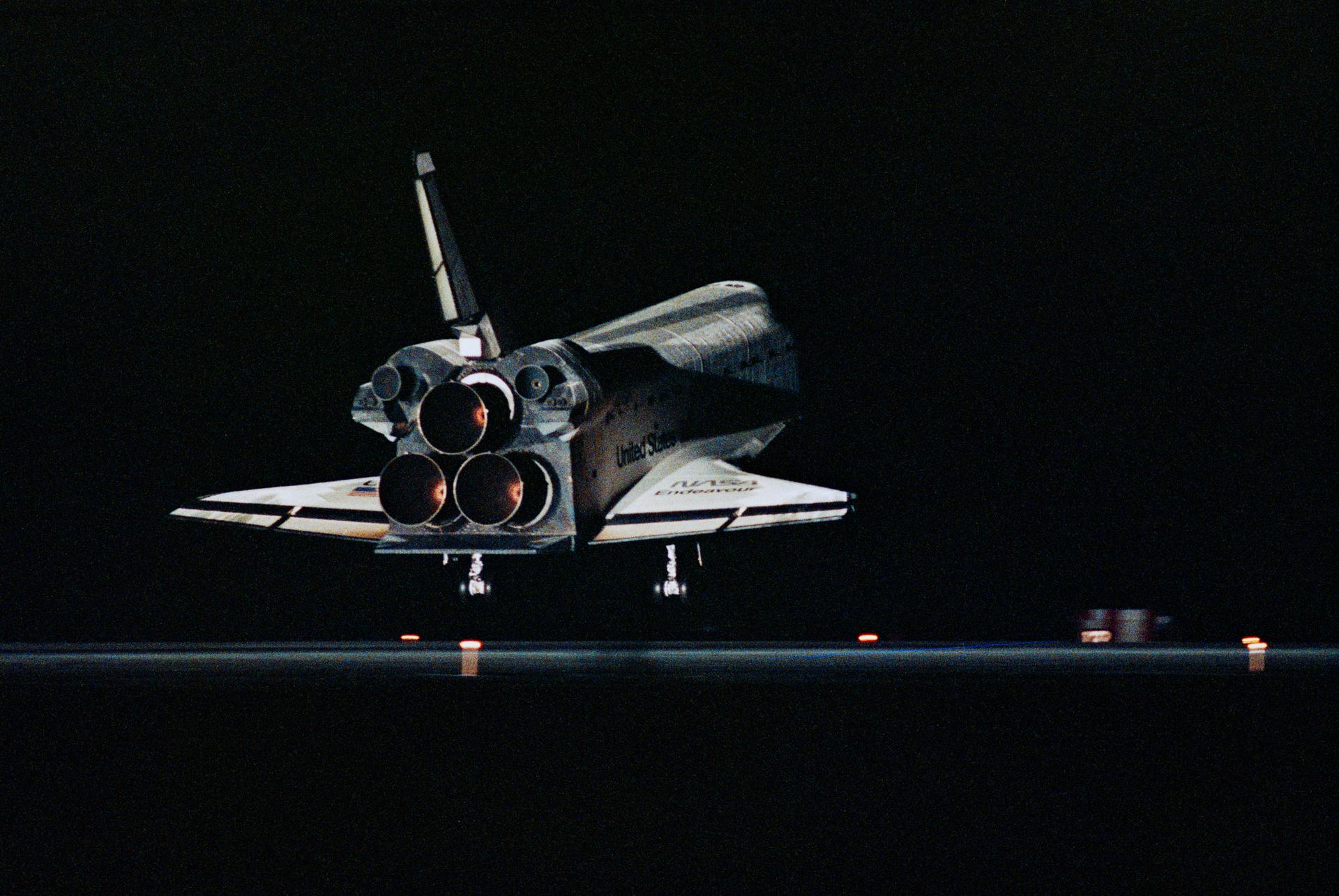 The Space Shuttle Endeavour is seen in the dark, from the back as it is about to touch down on the runway at Kennedy Space Center.