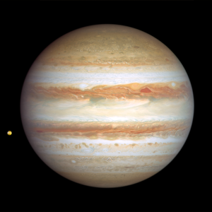 Image of Jupiter taken on January 6, 2024. This side of Jupiter is also banded in stripes of brownish orange, light gray, soft yellow, and shades of cream, with many large storms and small white clouds punctuating the planet. At upper right of center, a pair of storms appear next to each other: a deep-red, triangle-shaped cyclone and a reddish anticyclone. Toward the far-left edge of this view is Jupiter's tiny orange-colored moon Io.