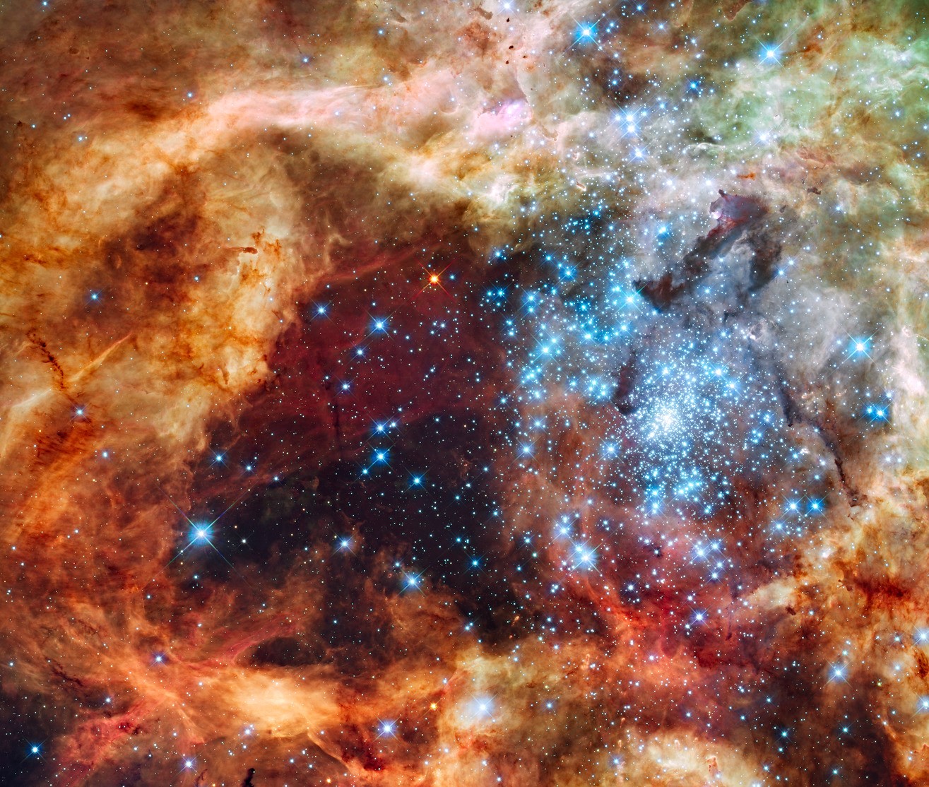 A colorful red, orange, and brown and dust cloud with a bright blue star cluster on the right side.