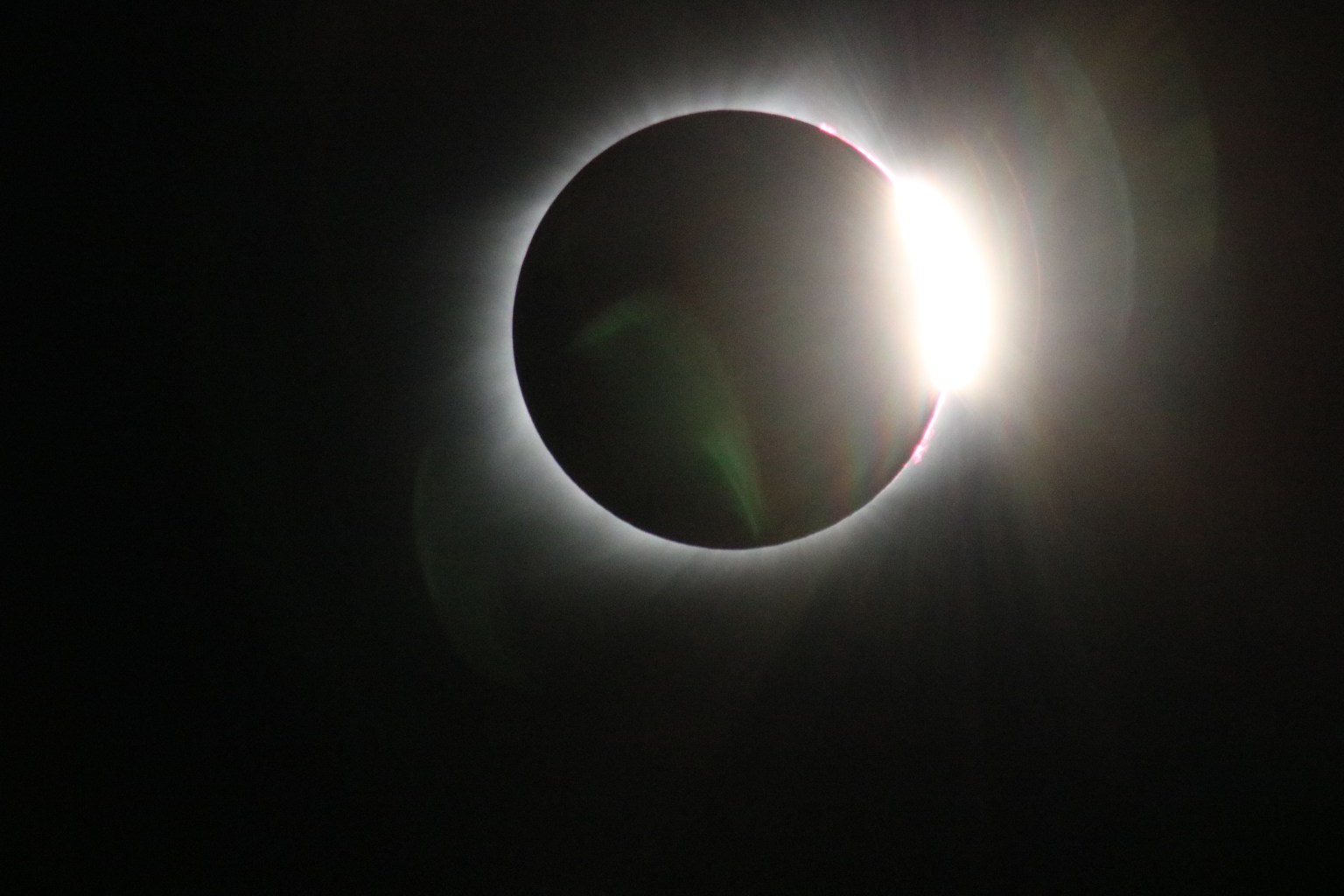 The eclipsed Sun. In the upper right area of the eclipse, there is a bright flood of white light.