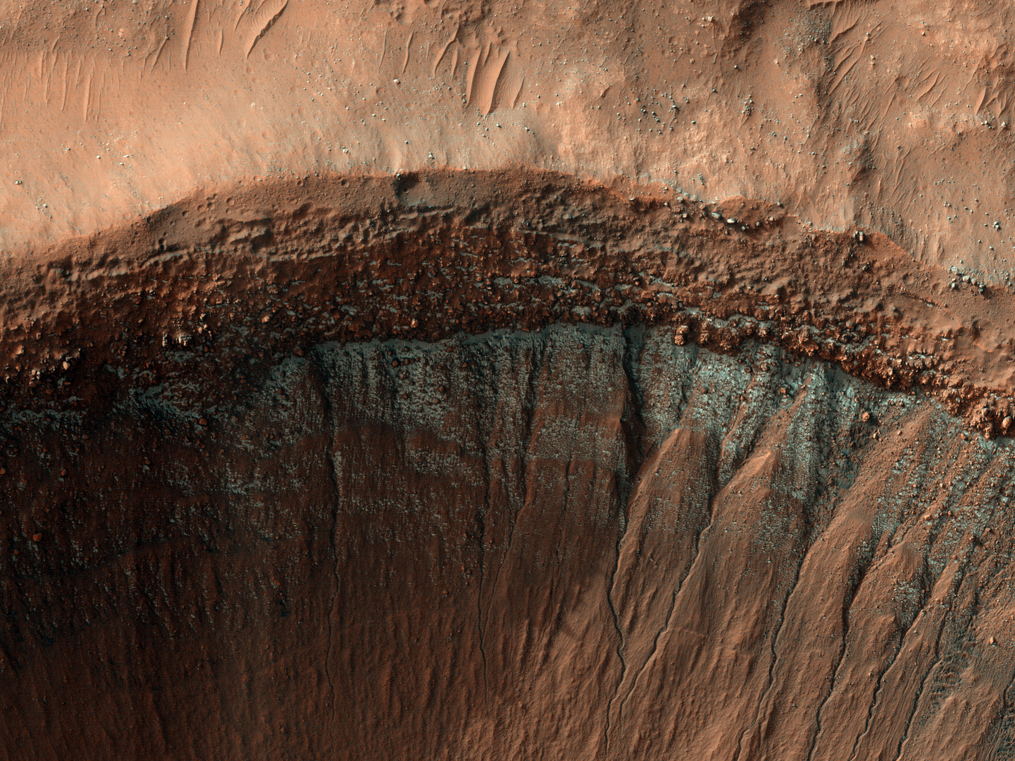 This image was taken in the middle of winter in Mars’ Southern Hemisphere, and shows a crater near 37 degrees south latitude. The south-facing slope has patchy bright frost, blue in enhanced color.
