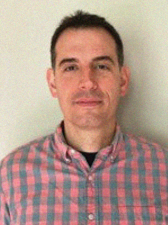 Headshot of Christopher Mendillo, male, black hair, plaid button down shirt.