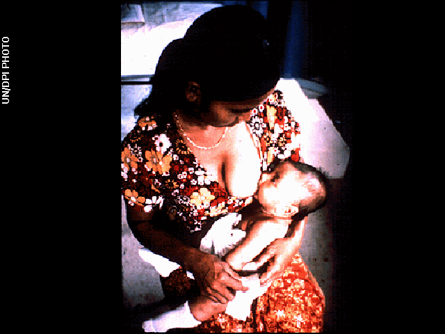 A woman holding and nursing an infant