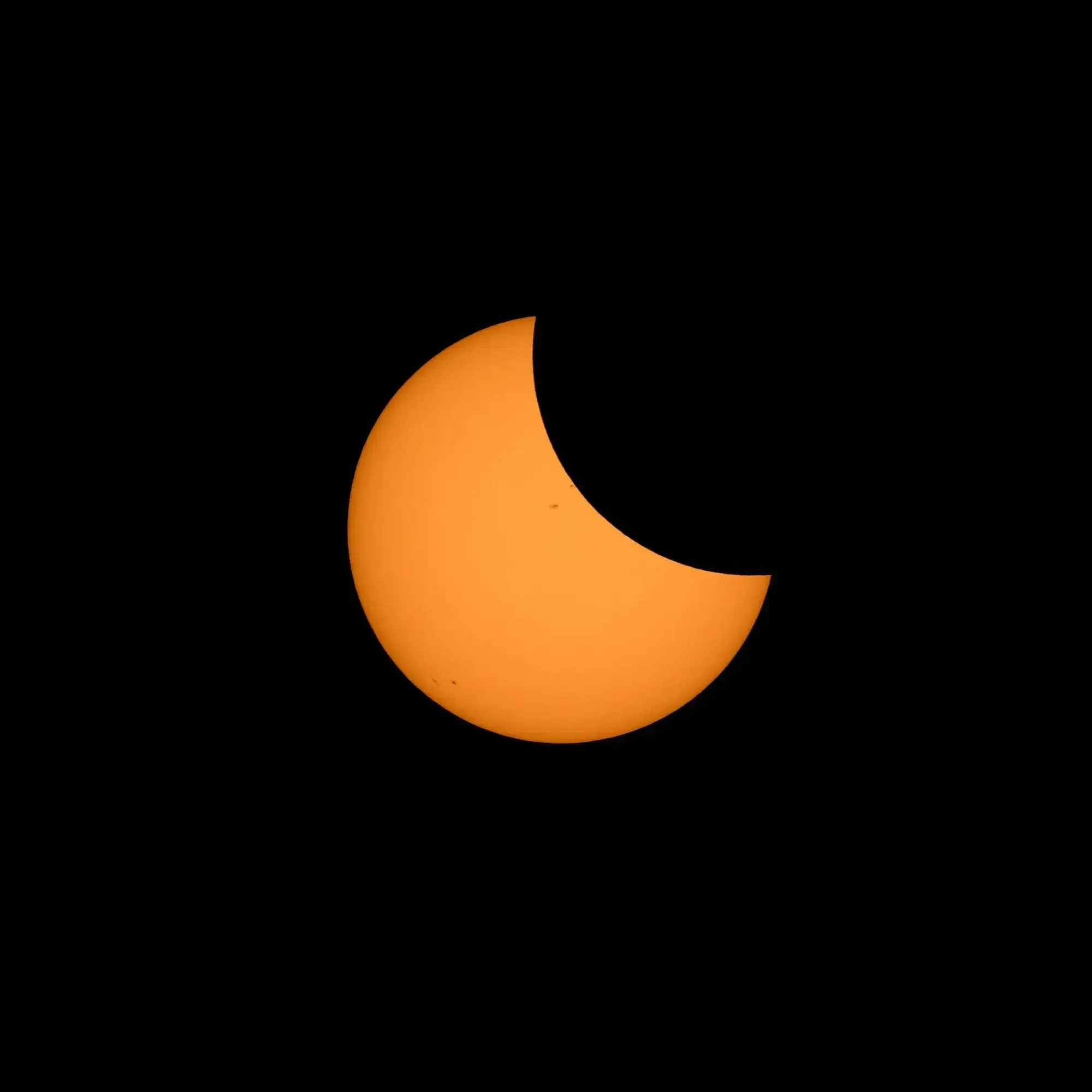 The Sun against a black background. The top right area appears to be scooped out where it is blocked by the Moon, like a crescent.