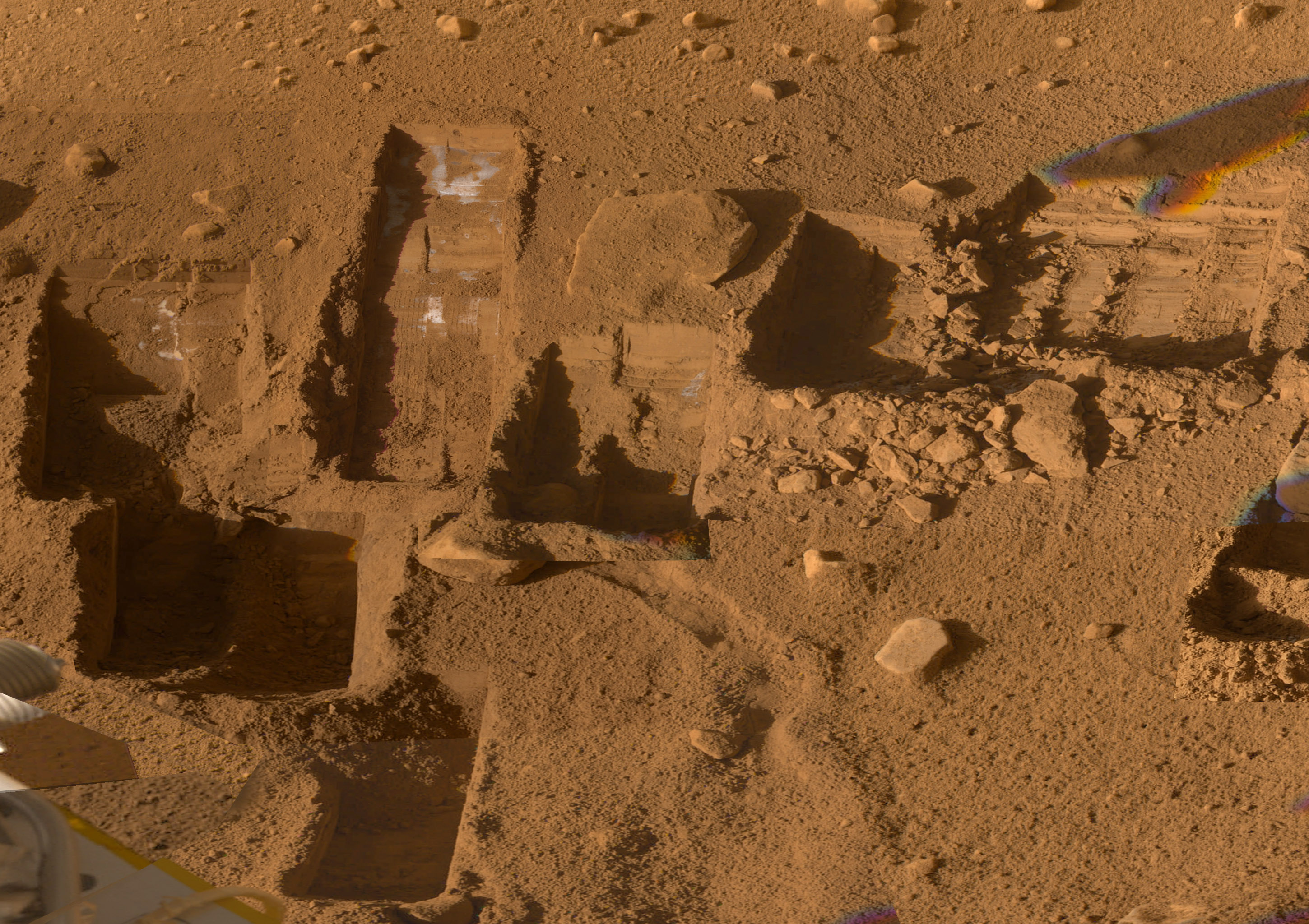 Loose Martian soil is marked with square scoops where the lander collected samples.