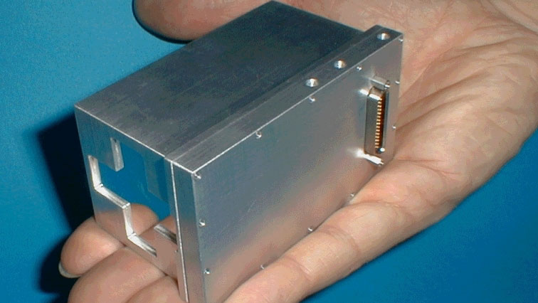 The spectrometer is a silver box about the size of an adult hand.