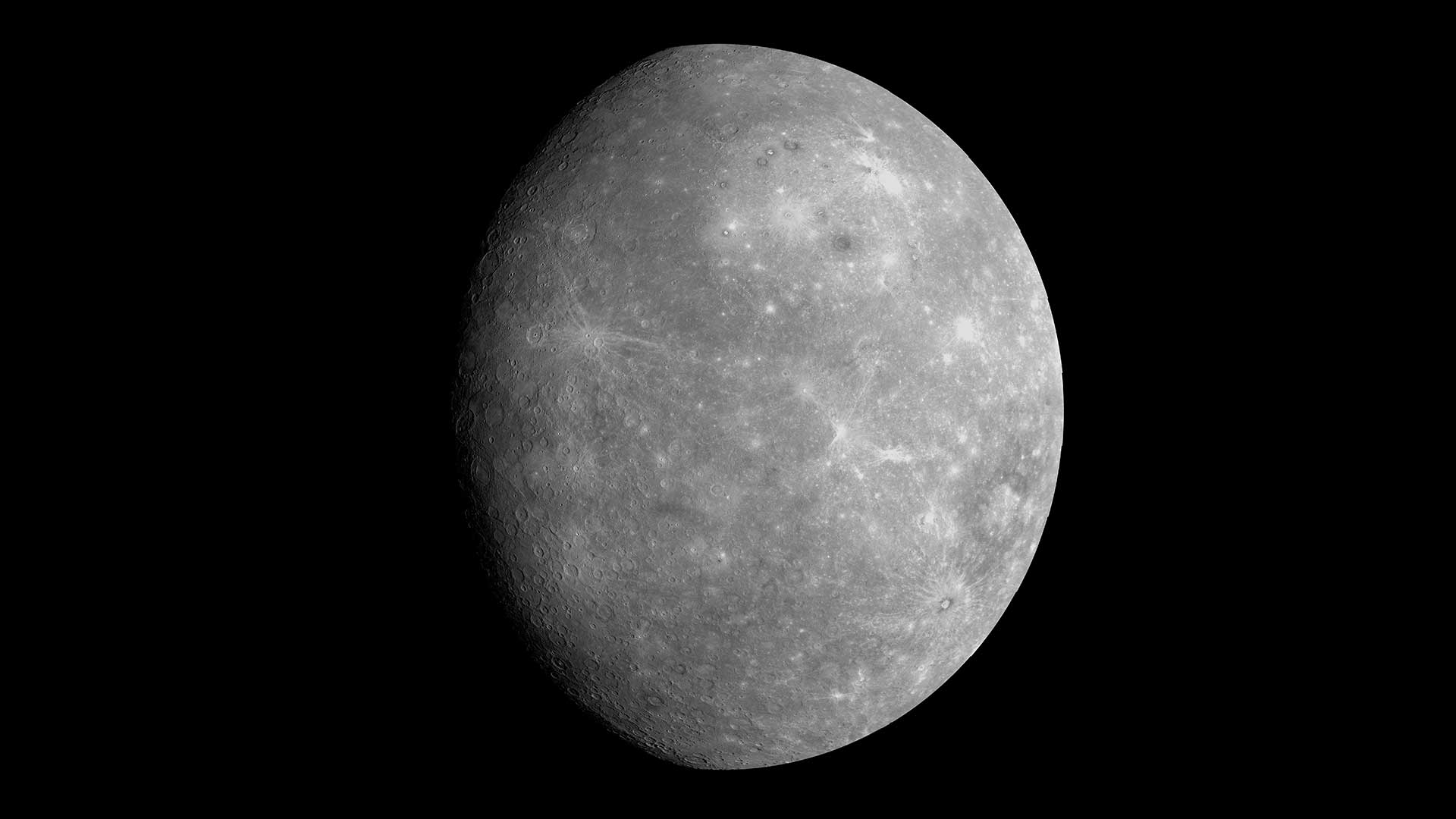 Mercury is gray with bright white patches, and craters visible in this image from the MESSENGER spacecraft.