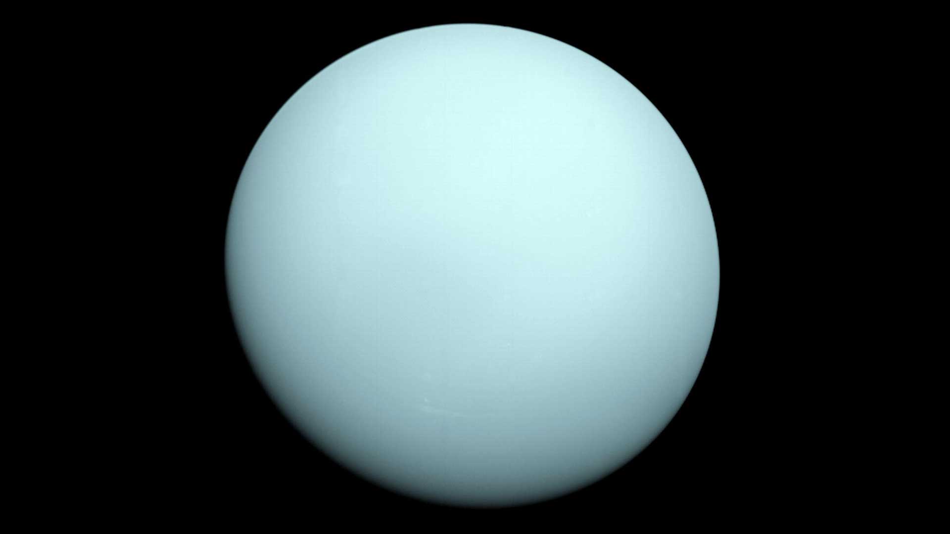Pale blue planet Uranus is seen against the darkness of space in an image from the Voyager 2 spacecraft.