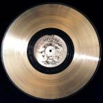 A golden record album with The Sounds of Earth United States of America, Planet Earth and etched with "To the makers of music, all worlds, all time."