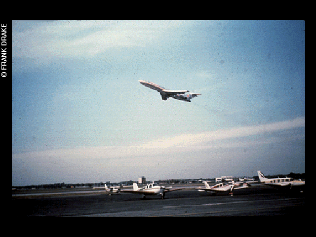 An airplane taking off from an airport into a blue sky