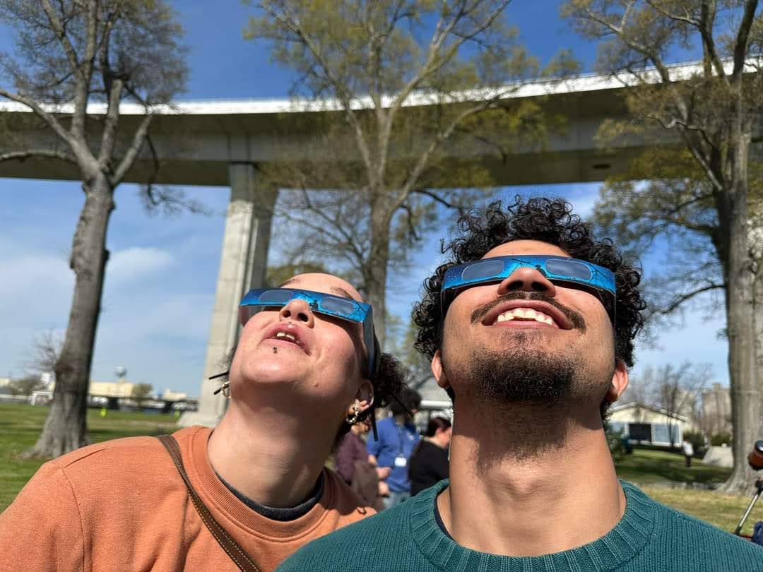 two people looking at the Sun with safe solar glasses