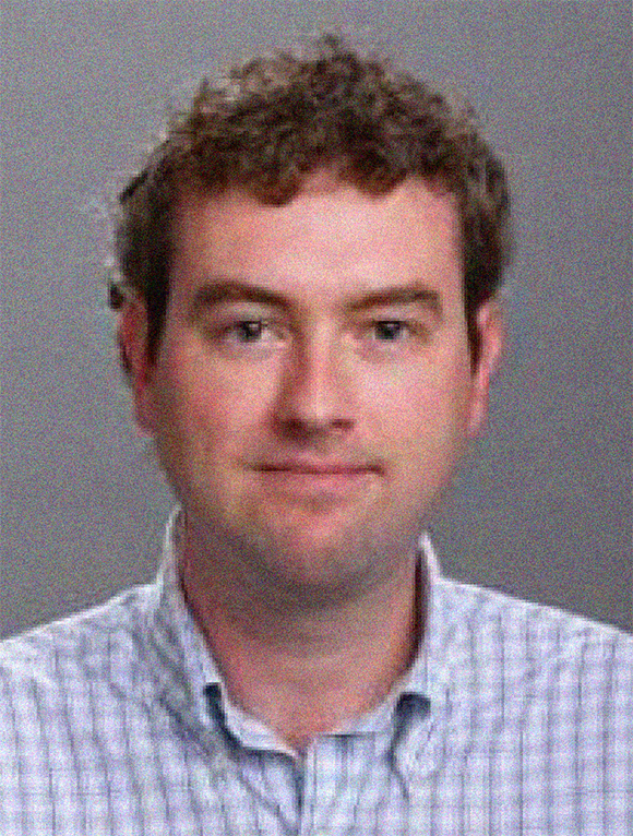 Headshot of Cullen Blake, male, reddish brown hair, blue button-down plaid shirt.