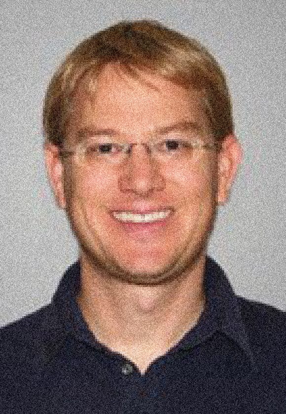 Judd Bowman headshot, male, blonde hair, glasses, big smile.