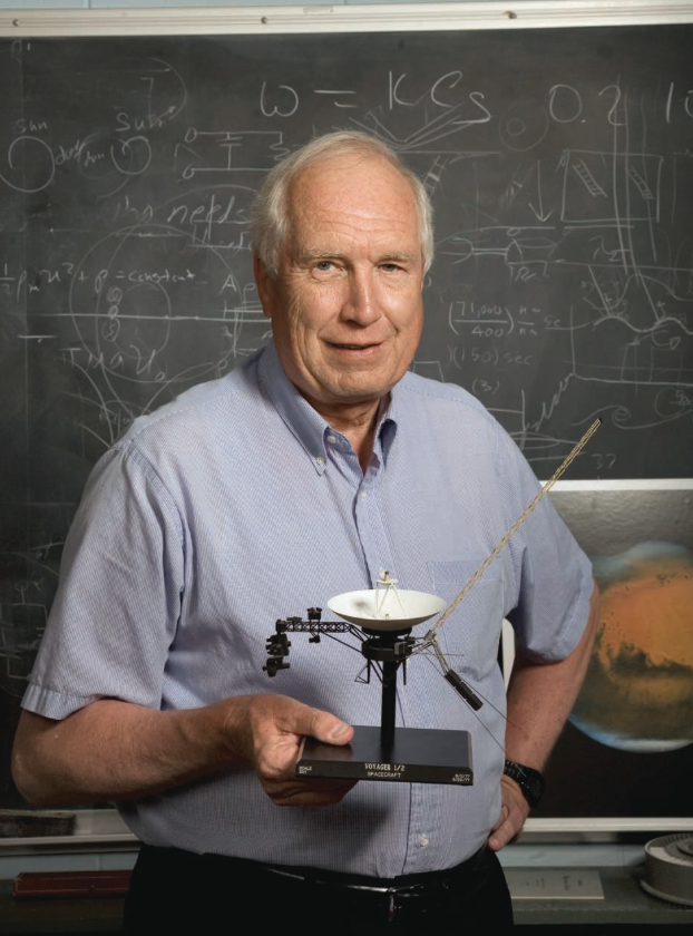 Portrait of Don Gurnett, holding a small model of Voyager