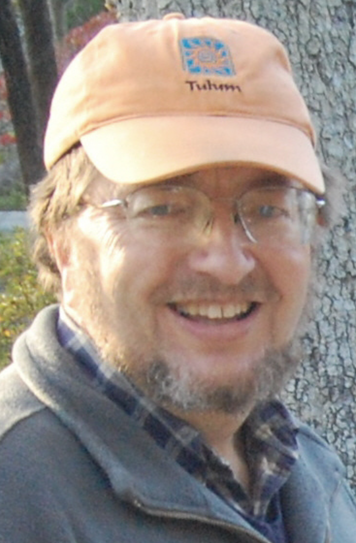 Portrait of John Cooper, wearing a tan baseball cap