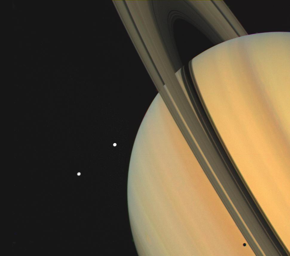 Two small moons orbit Saturn in this expansive view of half the planet and its rings.