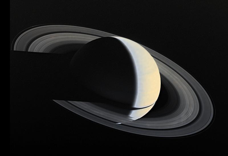 Cloaked in darkness, Saturn casts a shadow across its rings - a view that can only be seen from beyond Saturn.