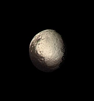 Half of a small moon is covered in dark terrain, while the other lighter hemisphere stands out in stark contrast.