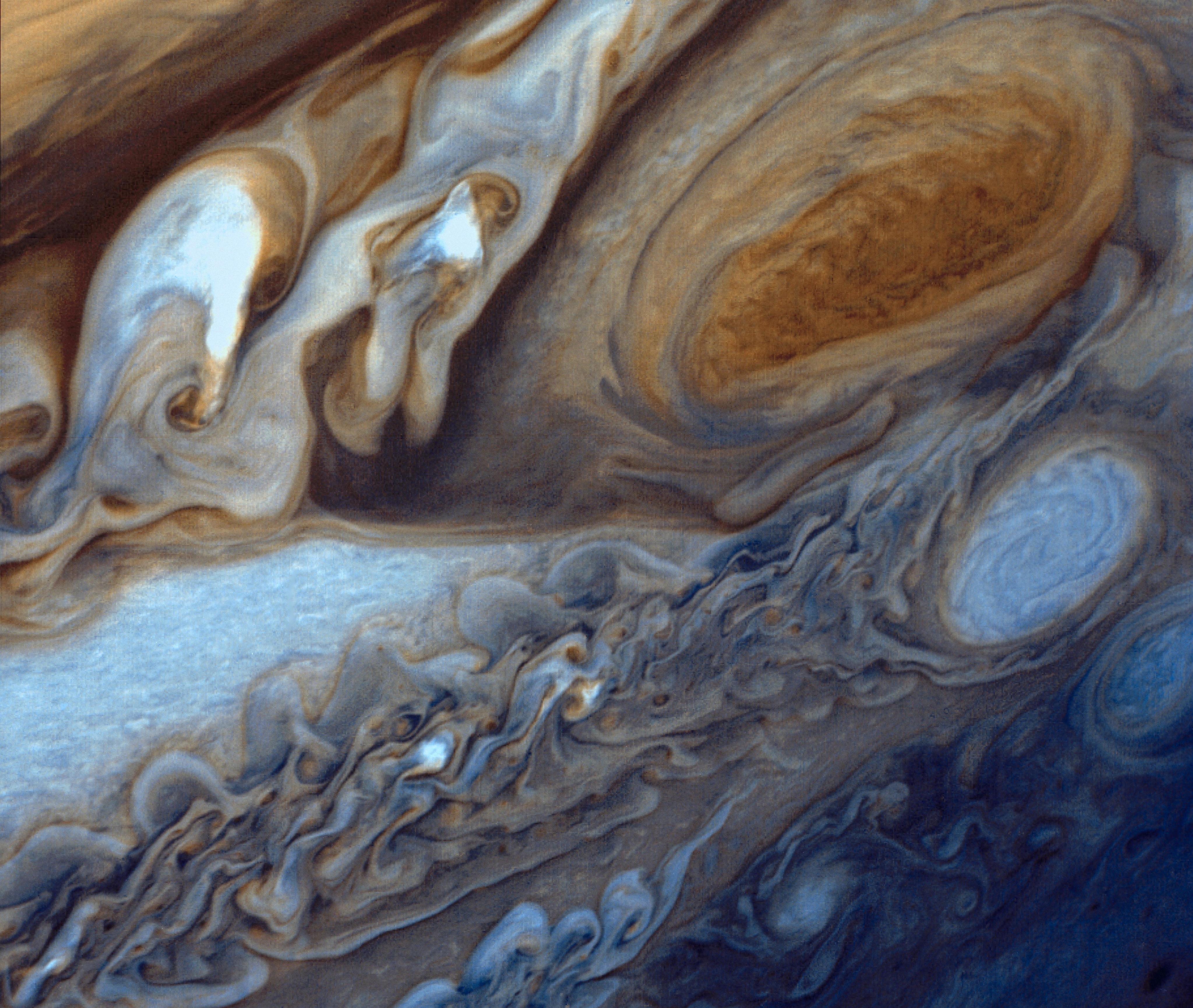 Intricately swirling clouds surround the oval shape of the Earth-sized Great Red Spot.