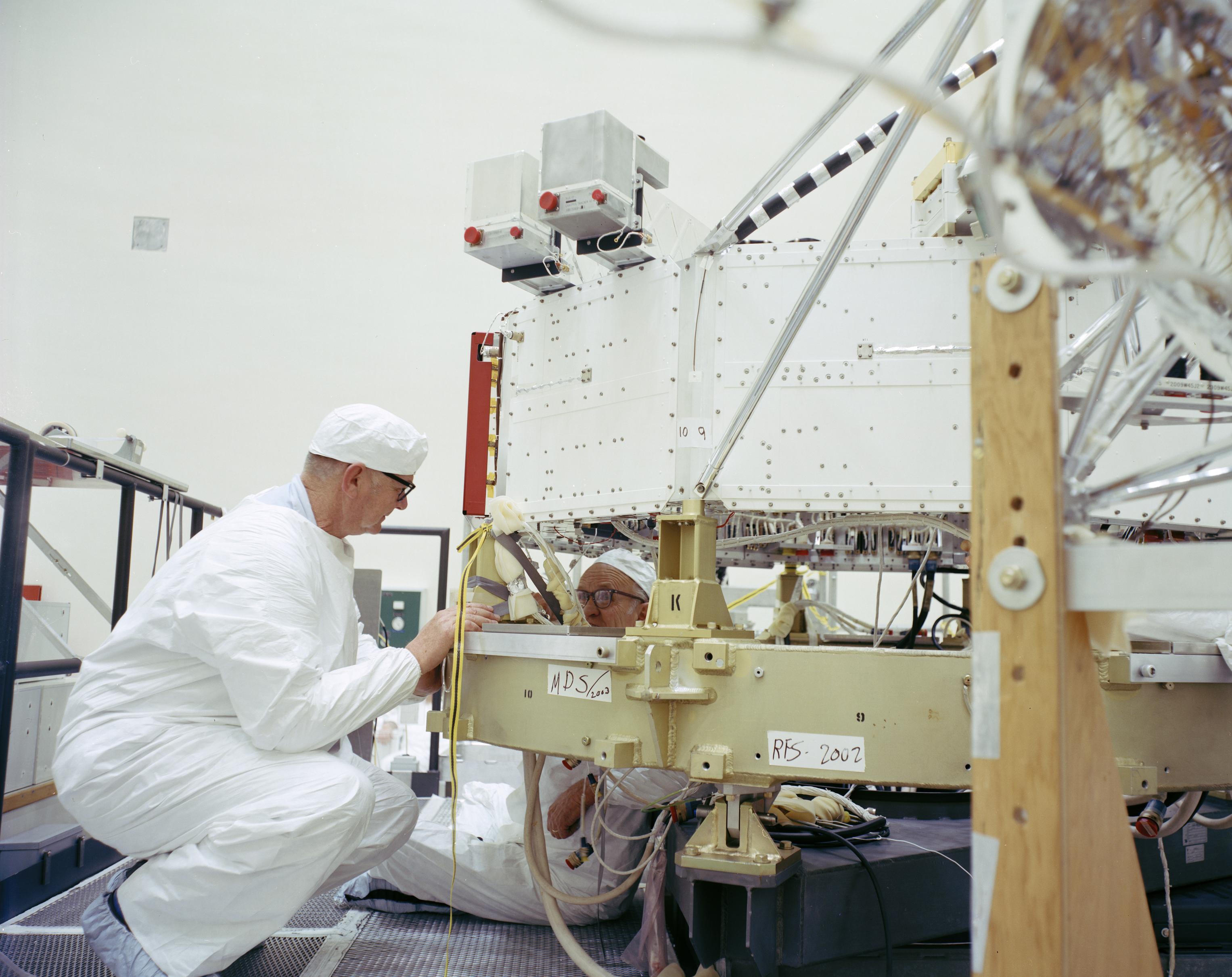 Engineers at NASA's Jet Propulsion Laboratory working on the 10-sided central structure, or "bus," of the Voyager 2 spacecraft